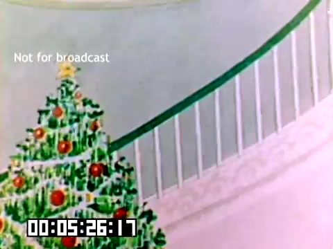 The still features a brightly decorated Christmas tree adorned with colorful ornaments, situated near a staircase. The backdrop suggests a festive setting, likely intended to evoke a warm, holiday atmosphere. The text 'Not for broadcast' appears at the top, indicating this footage is meant for internal use. A timestamp displays '00:05:26:17,' revealing its position within the film. Overall, the scene conveys a cheerful, nostalgic vibe, characteristic of 1970s holiday promotions.