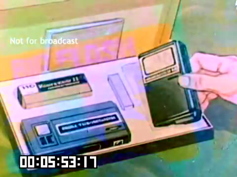 The still shows a hand holding a device, possibly a film camera or video recorder, above an open box containing various Kodak products. The items, arranged neatly, include a small camera or recorder and additional accessories. The image has a colorful, vintage aesthetic typical of the 1970s marketing style. A disclaimer reads 'Not for broadcast' while a timestamp is shown at the bottom.