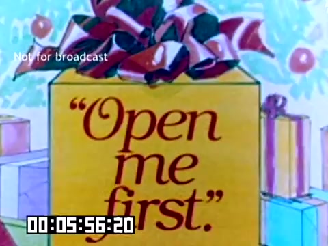 The still features a colorful, cartoonish gift box adorned with a large festive bow. The text on the box reads, “Open me first,” suggesting it's meant to capture attention and create anticipation. The background includes additional wrapped presents, setting a holiday or special occasion vibe. The overall aesthetic is bright and cheerful, typical of promotional materials from the 1970s.