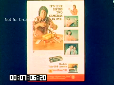 The still features an advertisement for the Kodak Tele 608 camera, emphasizing its dual functionality with the tagline, 'IT'S LIKE GIVING TWO CAMERAS IN ONE.' The image showcases a man, likely presenting or unboxing the camera, surrounded by various photographic scenes. The design includes additional photos illustrating its use, reflecting a vintage aesthetic typical of the late 1970s. The bottom corner notes that the content is 'Not for broadcast.'