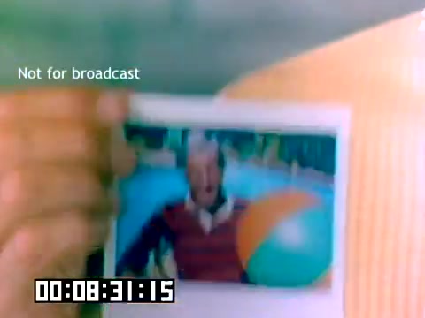 The still depicts a hand holding a photograph featuring a man smiling joyfully, likely by a pool, with a beach ball nearby. The image is bright and colorful, typical of 1970s promotional materials. The text onscreen indicates that this is not for broadcast, and a timestamp is displayed at the bottom. The overall tone suggests an upbeat, family-friendly atmosphere, consistent with Kodak's branding during that era.