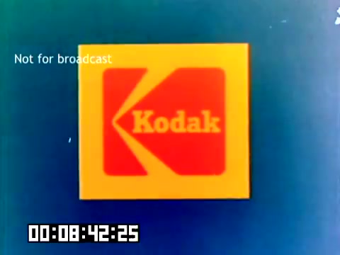 The still showcases the iconic Kodak logo prominently displayed against a blue background. The logo features a bold, red and yellow design typical of 1970s branding. In the corner, there's a note stating 'Not for broadcast,' indicating it’s intended for internal or promotional use only. A timestamp is visible at the bottom, suggesting the timing of the film segment. The aesthetic reflects the vintage style associated with the era.