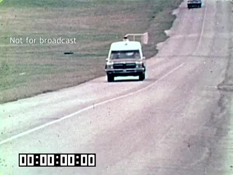 The still shows an ambulance driving along a road, highlighting the urgency of medical response in an Air Force context. The caption 'Not for broadcast' indicates it's an instructional or internal film segment. The overall theme focuses on addressing gangrene to save lives, emphasizing the critical role of swift medical transport.