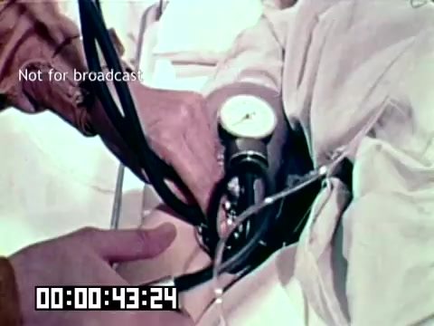 The still depicts a medical professional taking a patient's blood pressure using a sphygmomanometer, presumably as part of a medical procedure aimed at addressing gangrene and saving lives. The film likely emphasizes the importance of timely medical intervention in critical conditions. The overlay notes 'Not for broadcast,' indicating the content is intended for internal use or specific audiences.