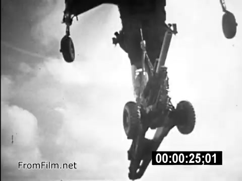 The still captures a CH-54 helicopter, specifically highlighting its landing gear as it descends through the sky. The focus is on the mechanical details of the helicopter, emphasizing the role of flight engineers like Specialist 6 James Daly during the Vietnam War. This visual is part of a public service announcement designed to showcase the realities of military life and recruitment in that era. The stark black-and-white imagery underscores the serious and impactful nature of the content.