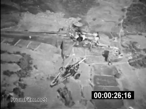 The still from 'Your Man In Vietnam' PSA captures a CH-54 helicopter in flight, showcasing its significance in military operations during the Vietnam War. The image emphasizes the role of Specialist 6 James Daly as a flight engineer, highlighting the equipment used and the challenging environment faced by U.S. Army personnel. The aerial perspective underscores the rugged terrain of Vietnam, reflecting the realities of military life and recruitment efforts during that era.