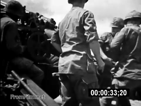 The still from 'Your Man In Vietnam' features U.S. Army soldiers engaged in an operation, highlighting the teamwork and urgency of military life during the Vietnam War era. Soldiers are shown in military fatigues, working together around a mounted artillery piece, underscoring the intensity and challenges faced by service members. This PSA aims to illustrate the realities encountered by American troops, with a focus on Specialist 6 James Daly and his role as a CH-54 flight engineer.