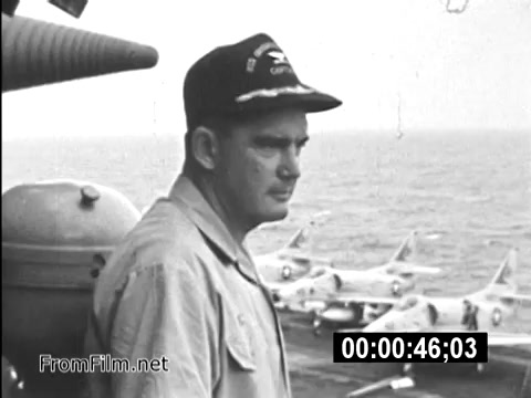 The still from 'Your Man In Vietnam' features a U.S. Army Specialist, identified as James Daly, wearing a military cap and looking thoughtfully over the sea. In the background, several aircraft are visible, highlighting the military context of the Vietnam War. This PSA captures the essence of daily life for service members during the era, emphasizing the operational environment and the personal experiences of those on duty.