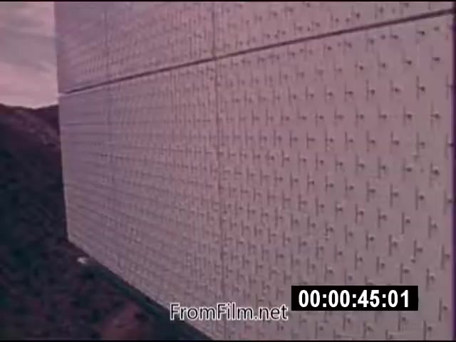 The still from the 16mm film 'Energy From Space' features a close-up view of a textured wall, likely related to energy technology or infrastructure. The image is colored and captures a scene from September 1976, showcasing NASA's actualities. It appears to depict elements of solar or energy harvesting technology, aligning with the theme of space-derived energy. The film is silent and runs for approximately 1 minute and 46 seconds.