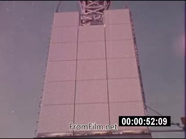 The still from 'Energy From Space,' a 16mm film shot in September 1976, depicts a large structure resembling a solar panel or energy receiver. The footage, classified as actuality, captures a clear sky background, showcasing the technology designed for harnessing energy from outer space. The film is silent and runs for a total of 1 minute and 46 seconds, highlighting innovative energy concepts from NASA during that era.
