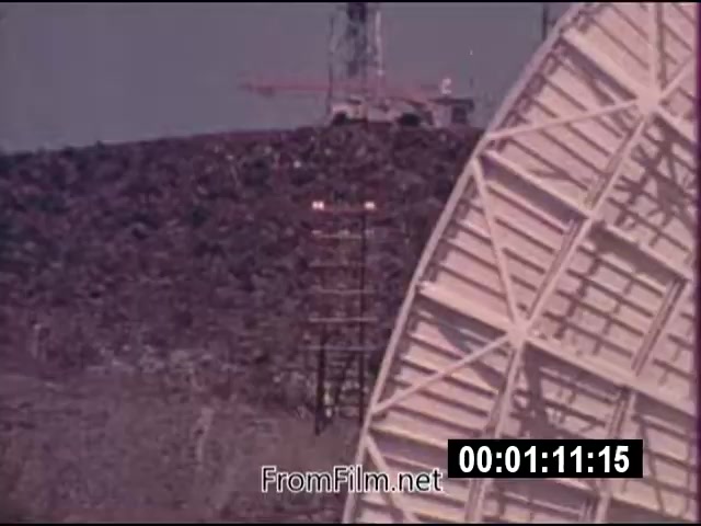 The still from 'Energy From Space,' a 16mm film produced by NASA in September 1976, shows a large dish structure, possibly a satellite or energy receiver, set against a backdrop of a rocky terrain. The date indicates it captures actuality footage, likely demonstrating early exploration into harnessing energy from space. The film is silent, running for 1 minute and 46 seconds, and is intended for news broadcasting.