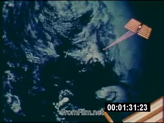 The still from 'Energy From Space' depicts a view of Earth from space, highlighting the planet's surface along with a satellite equipped with solar panels. This 16mm silent color footage, dated September 1976, features a focus on the concept of harnessing energy from space. The satellite is shown potentially transmitting energy, emphasizing advancements in space technology during that era. The time code indicates that this specific frame occurs around 1 minute and 31 seconds into the footage.
