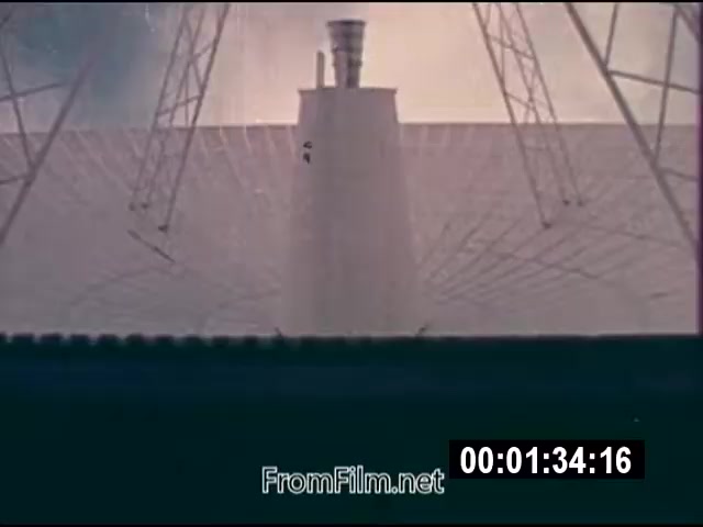 The 16mm still from 'Energy From Space' showcases a large, domed structure resembling a dish or satellite receiver, set against a background that hints at a futuristic energy harnessing project. The image is involved in the context of NASA's attempts to explore harnessing energy from space, likely featuring elements of solar energy technology. The shot is part of actuality footage from September 1976, designed for news broadcast, capturing pioneering concepts in energy generation. The film is silent but provides visual documentation of innovative scientific explorations of that era.