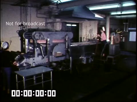 The still depicts a vintage industrial scene from 'DCA Food Industries - Making Frozen Novelties,' shot on Ektachrome in the 1950s-1960s. It features machinery used in food production, likely for frozen treats. Workers are visible, and the environment appears functional and organized. The text 'Not for broadcast' indicates that this footage is for internal use only. A timecode at the bottom suggests it may be part of a film or video project.