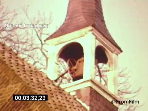 The still from 'Vincent Van Gogh: A Self-Portrait' (1961) depicts the bell tower of a church, capturing the architectural detail of the building with a vibrant color palette. The bell inside the tower is visible, and the image showcases the contrast between the textured roof and the clear structure of the tower. The scene is serene, hinting at the historical context of Van Gogh's life. Lee J. Cobb likely provides narration, enhancing the narrative depth of the film.