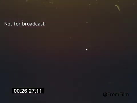 The still from 'Vincent Van Gogh: A Self-Portrait' (1961) features an abstract, blurred background with a slight illumination, creating a somber and introspective mood. The image lacks clear details, emphasizing atmospheric elements, which likely reflect Van Gogh's emotional depth. The film, narrated by Lee J. Cobb, explores the life and artistry of Van Gogh, capturing his complexities through visual interpretation.