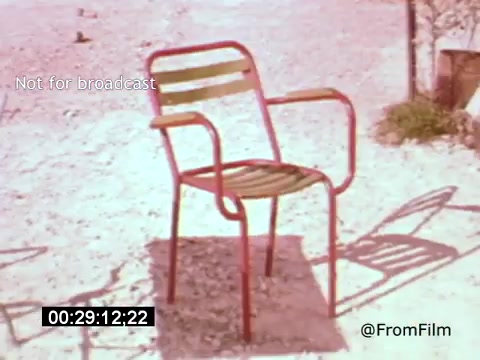 The 16mm still from 'Vincent Van Gogh: A Self-Portrait' (1961) features a solitary red and green striped chair set against a sandy background. The composition emphasizes the chair's vibrant colors, capturing a serene, introspective moment. This visual serves to reflect themes of isolation and artistic contemplation, resonating with Van Gogh's own experiences. Lee J. Cobb narrates, adding a layer of depth to the scene.