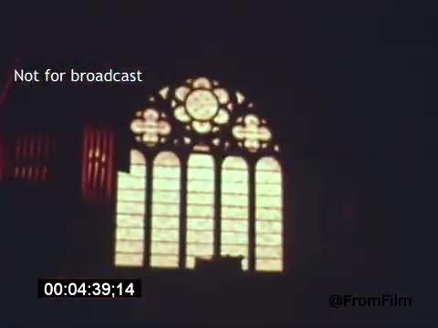 In this still from 'Vincent Van Gogh: A Self-Portrait' (1961), the focus is on a beautifully lit stained glass window, likely situated in a church or an artistically significant location. The light filters through the intricately designed glass, casting a warm glow that emphasizes the colors and patterns. The composition, combined with the somber ambiance, hints at the contemplative themes of the film, which features Lee J. Cobb. The scene reflects the emotional depth associated with Van Gogh's work and life.