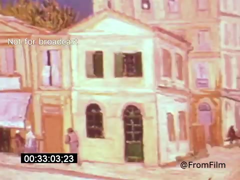 The still from *Vincent Van Gogh: A Self-Portrait (1961)* features a painted scene of a quaint street. It showcases a building with yellow and beige tones, black windows, and doorways, surrounded by other structures. Elements of Van Gogh's signature style, such as expressive colors and bold brush strokes, are evident. The shot captures a moment in the film that likely reflects Van Gogh's artistic environment, contributing to the portrayal of his life and work.