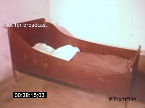 The still from 'Vincent Van Gogh: A Self-Portrait' (1961) depicts an empty, rustic bed with a simple blanket partially covering it, set against a plain wall. The scene conveys a sense of solitude and introspection, reflecting Van Gogh's turbulent emotional state. The absence of a person emphasizes themes of isolation and mental struggle, key elements in Van Gogh’s life and work.