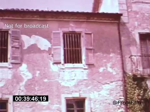 The still from 'Vincent Van Gogh: A Self-Portrait (1961)' features a weathered building with peeling paint and closed shutters, conveying a sense of history and melancholy. The muted colors enhance the reflective mood, aligning with Van Gogh's introspective nature. This moment, part of a film narrated by Lee J. Cobb, captures the essence of Van Gogh's artistic journey and surroundings.