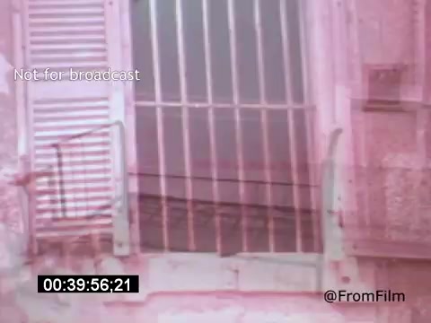 The 16mm still from 'Vincent Van Gogh: A Self-Portrait' (1961) features a barred window with shutters, creating a somber atmosphere. The muted colors and soft focus evoke a dreamlike quality, akin to Van Gogh's emotional landscape. The presence of the bars suggests captivity, reflecting the artist's tumultuous life. This visual complements Lee J. Cobb's narrative, enhancing the film's exploration of Van Gogh's psyche.