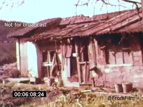 The still from 'Vincent Van Gogh: A Self-Portrait' (1961) features a rustic, dilapidated building, showcasing an earthy color palette typical of the film's period aesthetic. The structure has a weathered wooden roof and an unfinished appearance, reflecting the artist's tumultuous life. The image effectively evokes a sense of place and time, drawing viewers into Van Gogh's world. The scene likely sets a contemplative mood, aligning with the themes explored in the film.