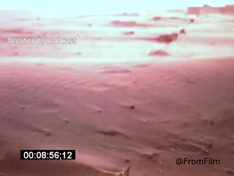 The still from 'Vincent Van Gogh: A Self-Portrait' (1961) presents a desolate landscape, characterized by sandy terrain and minimal vegetation. The color palette leans towards warm hues, suggesting a heightened contrast or unique filming technique. The environment evokes a sense of isolation and introspection, reflective of Van Gogh's artistic spirit. Lee J. Cobb's presence hints at a narrative exploration of Van Gogh's life and struggles.