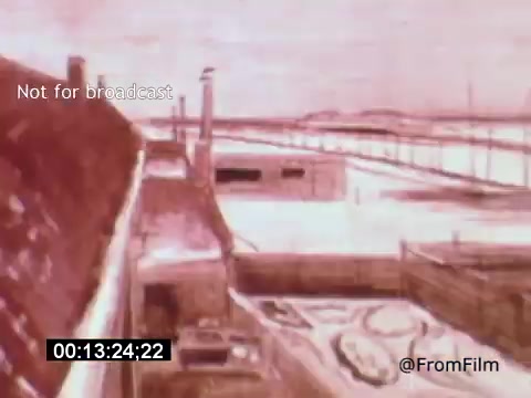 The still from 'Vincent Van Gogh: A Self-Portrait' (1961) features an animated or artistic representation of a landscape, likely depicting a rural setting with a farmhouse and distant structures. The palette is dominated by soft, muted tones, creating a contemplative atmosphere. This moment captures the essence of Van Gogh's style, reflecting his connection to nature and the emotional currents of his art, enhanced by Lee J. Cobb's narration.