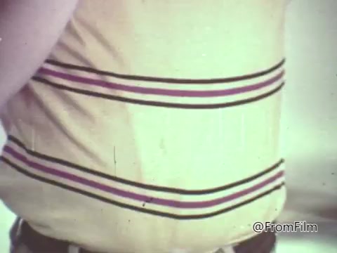 This 16mm still from a 1960s M&M's animated commercial features a close-up of a person wearing a striped shirt. The emphasis is likely on a playful or humorous interaction involving M&M's candies, typical of the lighthearted tone of that era's advertisements. The image captures a casual and nostalgic vibe reflective of its time.