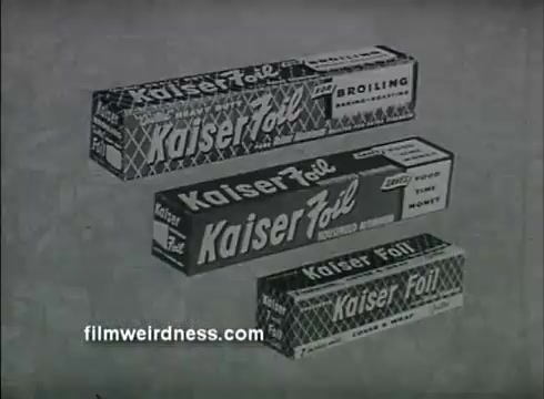 The still features three boxes of Kaiser Aluminum foil, each with distinct sizes and designs. The boxes are labeled prominently with the brand name 'Kaiser Foil,' emphasizing its unique quilted texture. The background is simple, highlighting the products, which are marketed for various uses like broiling and cooking. The overall aesthetic is vintage, typical of mid-20th century advertising.