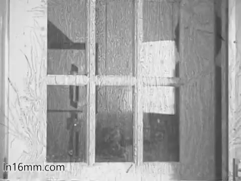The still from the 'Give Heart Fund PSA - 1960's' depicts a vintage-style window with multiple panes. The glass appears to be slightly fogged or distorted, giving an atmospheric effect. The overall tone is black and white, characteristic of the period, and suggests a focus on themes of care and awareness related to heart health.