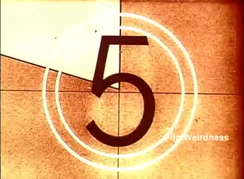 The still features a retro countdown leading with the number '5,' framed in a circular design, typical of film projections from the 1970s. The background has a textured, warm tone, likely reflecting the vintage aesthetic of the time. This particular frame serves as a transition point, reminiscent of classic film techniques, evoking nostalgia for the era of Bell System's technological evolution in telecommunications.