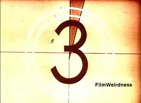 The still depicts a countdown frame from a 16mm film, specifically showing the number '3' in a vintage style. The background has a faded, yellowed look typical of older films, with circular markers indicating the countdown. This frame likely serves as an introduction or transition within the film 'Bell Performance,' which features nostalgic footage related to the production of telephones and the Bell System. The lack of titles adds to the film's authentic retro feel.