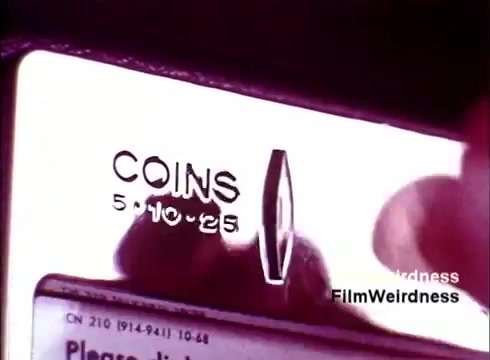 The still depicts a close-up of a coin slot on a telephone, showcasing the embossed text 'COINS' alongside denominations of 5, 10, and 25 cents. The metallic surface reflects a nostalgic aesthetic and the surrounding lighting suggests a vintage setting, likely emphasizing the technology of that era. This image evokes a sense of nostalgia for the past telecommunications era associated with the Bell System.