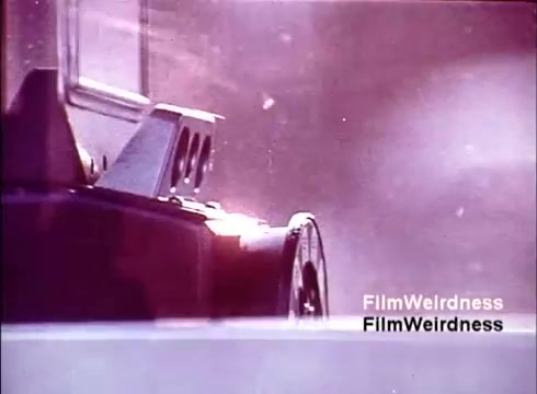 The 16mm still from 'Bell System Film from the 1970s' captures a close-up of a film reel, suggesting a focus on the production process. The soft, hazy lighting adds a nostalgic atmosphere, evoking memories of the era's technology. The absence of titles emphasizes the raw nature of the film, highlighting its historical significance as a glimpse into the creation of telephones and the workings of the Bell System.