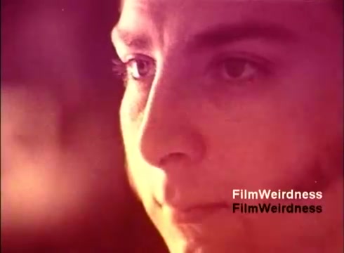 The still from the 'Bell System Film from the 1970s' features a close-up of a person’s face, capturing an expression of concentration or contemplation. The soft, warm color tones create a nostalgic atmosphere, enhancing the film's retro vibe. This moment likely reflects the human element behind the technology showcased in the film, which focuses on the creation and development of telephones. The image evokes a sense of connection to the past and the evolution of communication.