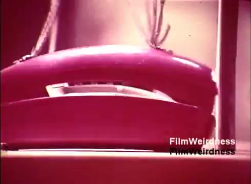 The still from the 'Bell System Film' showcases a close-up of a vintage pink telephone, likely from the 1970s. The phone is depicted in a vibrant, retro style, emphasizing the era's aesthetics. The film captures the production process and features nostalgic elements of telecommunications history, aligning with the theme of Bell System nostalgia. The absence of titles suggests a focus on the visuals of technology and craftsmanship associated with telephone manufacturing.