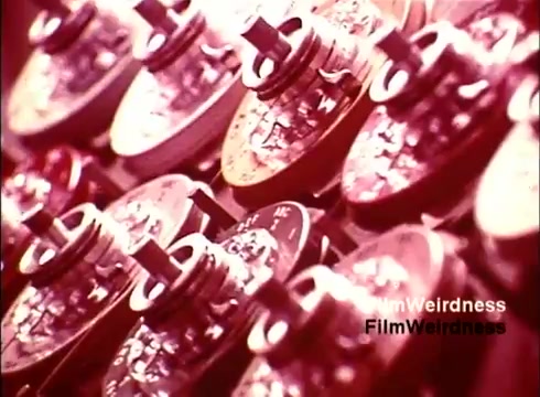 The still from 'Bell Performance' showcases a close-up view of intricate telephone components, likely highlighting the manufacturing process. The rich colors and detailed textures present a nostalgic snapshot of 1970s technology, emphasizing the craftsmanship behind telecommunications devices. The focus on gears and mechanisms suggests a celebration of innovation in the Bell System era.
