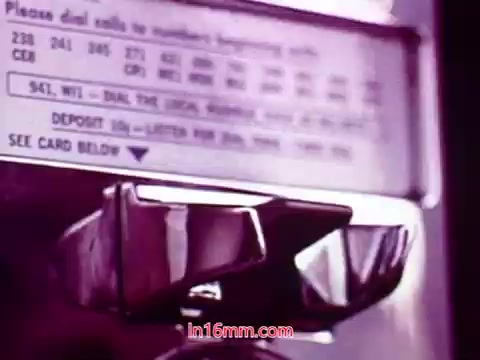 The still from the 16mm film 'Performance' depicts a close-up of a payphone. The focus is on the metal receiver and the dial, with visible instructions for dialing local numbers and depositing coins. The color tone suggests a vintage aesthetic, typical of the era in which the film was produced (1971). This frame likely serves as a segment related to communication, fitting into the broader themes of the film. It's part of the end titles, providing information on the production date and credits for the cast and crew.