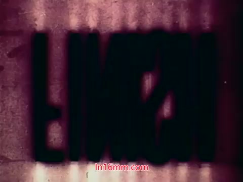 The still from the 16mm film 'Performance' features the end titles, which likely include the production date, cast, and crew credits. The visual is marked by a distinct graininess typical of 16mm prints, with a predominately purple hue and shadowy text that may appear slightly distorted or overlapping. This aesthetic contributes to a nostalgic feel, characteristic of films from the early 1970s. Overall, it signifies the conclusion of the film, summarizing its contributors and context.