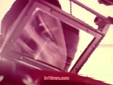 The 16mm still from 'Performance,' a 1971 Bell System film, features a close-up shot that emphasizes the face of an individual reflected in a surface. The image has a distinct color tone, hinting at a vintage aesthetic typical of the era. This still likely conveys an important moment from the end titles, showcasing production details such as the date and the credits for the cast and crew involved. The visual style captures the film's unique character, making it a significant piece of cinematic history.