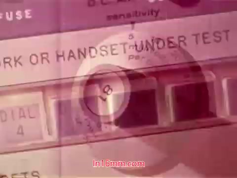 The still from the 16mm film 'Performance' (Bell System Film, 1971) features a close-up view of an analog device, possibly related to telecommunication testing. It prominently displays a dial with the setting '4' and reads 'MARK OR HANDSET UNDER TEST.' The visual may have a soft focus or color overlay, typical of film prints, contributing to a vintage aesthetic. The end titles likely include production dates and credits for cast and crew, completing the film's presentation.
