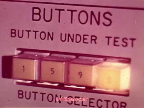 The still from 'Performance,' a Bell System Film from 1971, features a close-up of a test panel labeled 'BUTTONS.' It displays buttons marked with numbers, specifically highlighting '1,' '5,' and '9.' The illuminated button suggests it is currently active or selected, with an instructional or testing context implied. The overall design is reminiscent of technology from that era, emphasizing functionality and detail in button selection.
