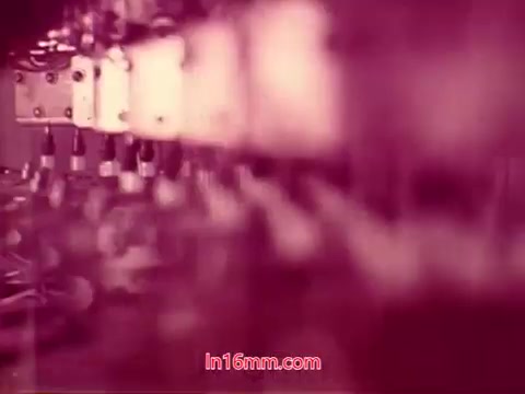 This still from the 16mm film 'Performance' shows an abstract, close-up view of a series of electronic components, likely conveying a sense of technology and innovation. The color palette features a blurred mix of reds and pinks, creating a visually striking effect. The image captures the film's focus on the intricate details of the Bell System's equipment, which ties into its themes of communication and performance. Given it's an end title frame, it likely displays production details, including the date and credits for the cast and crew.