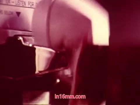 The still from 'Performance' (1971) shows a close-up of a film projector in action, emphasizing the mechanical aspect of film screening. The image captures the movement of film as it passes through the projector, highlighting the nostalgic quality of 16mm film. The colors are warm and slightly muted, typical of vintage prints. The end titles, which include production details and cast and crew credits, conclude the viewing experience, providing context for the film.