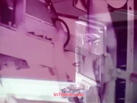 The still from the 16mm film 'Performance' (1971) features a visually striking composition with vibrant colors, primarily shades of pink and purple. It likely showcases industrial or technological elements, characteristic of the film's exploration of telecommunications themes. The end titles are visible, providing the production date along with the cast and crew credits. This moment encapsulates the film's era and artistic style, blending informative content with a unique visual aesthetic.