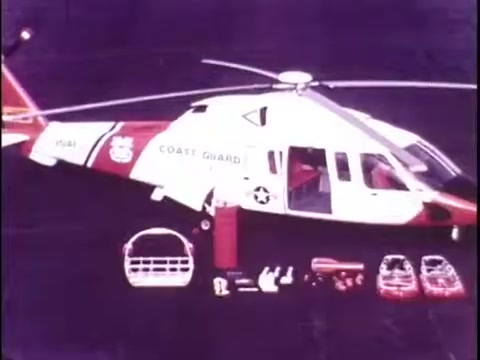 The still features a Sikorsky S-76 helicopter, prominently displaying its sleek design and distinct red and white color scheme. Marked with the 'COAST GUARD' label, the helicopter suggests its utility in search and rescue operations. Surrounding it are various equipment components, indicating its operational capabilities. The overall presentation showcases the helicopter's features and versatility, although the silent nature of the film leaves the viewer wishing for additional context or narration.