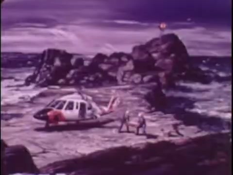 The still from the 1977 Sikorsky S-76 promo film depicts an illustrated scene of a Sikorsky S-76 helicopter on a rocky shoreline. The background features dramatic, stylized waves and a purple sky, enhancing the pop art aesthetic. Two figures are depicted approaching the helicopter, suggesting a narrative of adventure or rescue. This silent workprint evokes a sense of bold and dynamic technology associated with the Sikorsky brand.