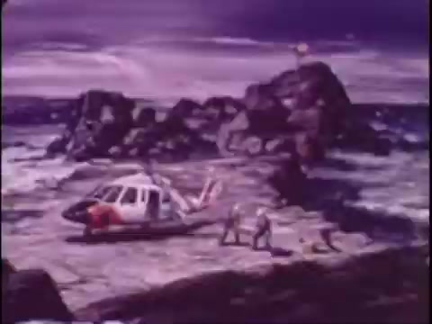 The still from the 1977 Sikorsky S-76 promo film features a stylized illustration of a helicopter on a rocky shore, surrounded by turbulent water. The sky has a dramatic, purple hue, adding a sense of urgency and adventure. Nearby, a few figures are depicted, possibly crew members, engaging with the helicopter. The overall composition blends elements of realism with a pop art aesthetic, capturing the essence of aviation innovation in the era.